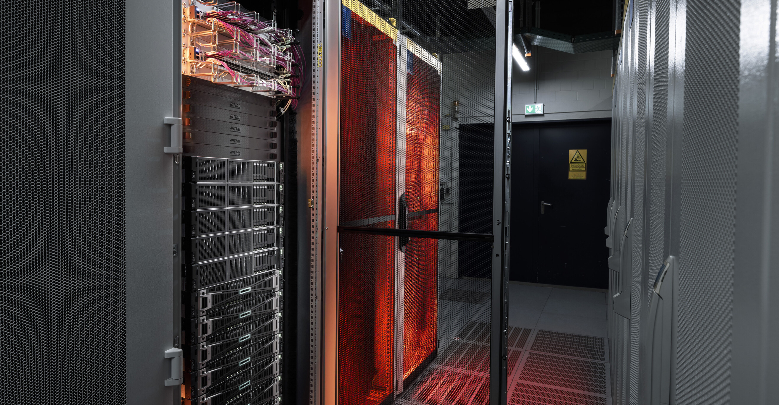 Strežniki sistema Edge Cloud, osvetljeni z oranžno svetlobo.